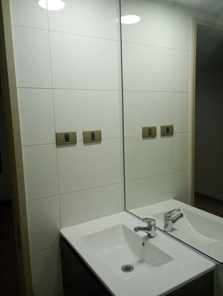 Lavamanos, espejo y revestimientos de baño después de limpieza profunda