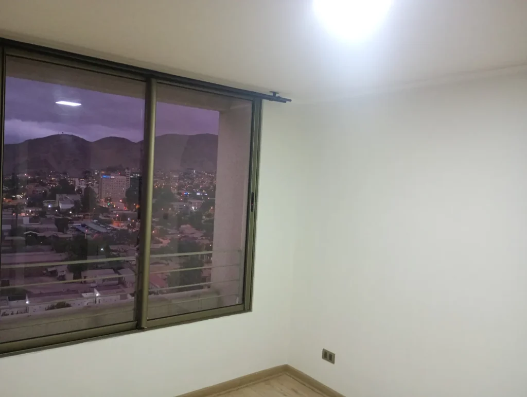 Dormitorio con muros pintados y ventana limpia después del trabajo