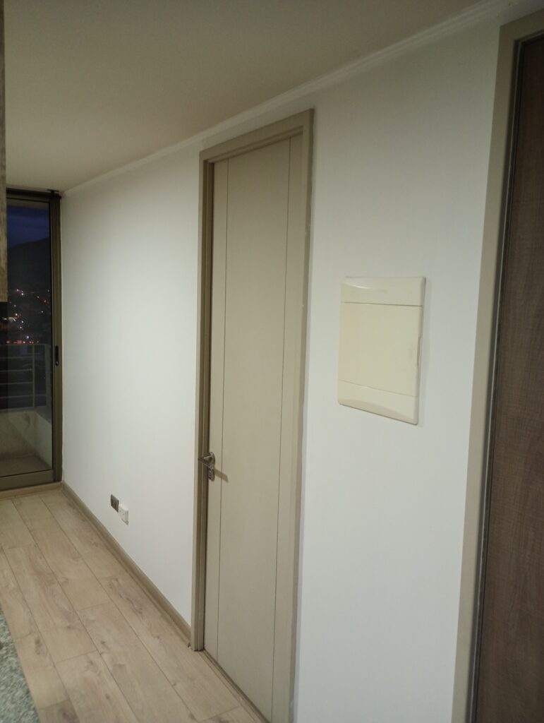 Pasillo, puerta y muros de un departamento después de pintura y limpieza